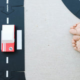 Top view of the Candylab red racing candycar on a toy road next to a childs feet