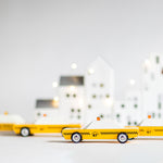 Candylab collectable wooden diecast car toys on a white background in front of some white toy houses