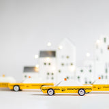 Candylab collectable wooden diecast car toys on a white background in front of some white toy houses