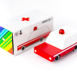 Candylab wooden ambulance toy on a white background next to its cardboard box