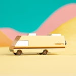 Candylab childrens diecast wooden campervan toy on a yellow background in front of some orange and pink hills
