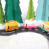 3 Candylab handmade wooden toy trucks driving on a toy road in a snowy Winter scene