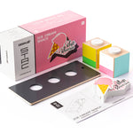 Pieces of the Candylab handmade wooden ice cream shack set on a white background next to the pink box