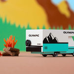 Close up of the Candylab collectable olympic rv toy on a brown background in front of a colourful mountain background