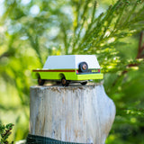 Candylab eco-friendly collectable wooden suv toy on a wooden post in front of some green leaves