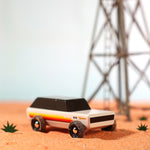 Candylab Wanderer SUV car toy on some orange sand next to a miniature tower