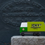Close up of the Candylab Icky's garbage truck on a large stone in front of a dark grey wall