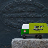 Close up of the Candylab Icky's garbage truck on a large stone in front of a dark grey wall