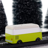 Side view of the CandyLab green VW T1 Campervan - driving through a snowy forest. 