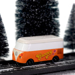 CandyLab orange VW T1 Campervan with 'Groovy' text on the side in a 60s font - driving through a snowy forest.