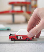 Adult hand pushing a Candylab hachigo red toy car on a playroad showing scale