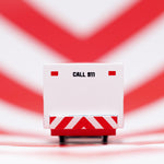Close up of the back of the Candylab solid wooden ambulance van toy on a red and white striped background