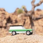 Side of the Candylab eco-friendly wooden big sur car toy on a large rock in front of a beige background