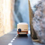 Close up of the Candylab childrens rv vehicle toy driving on a rubber road between two large rocks