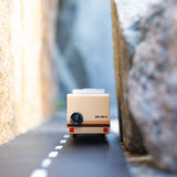 Close up of the Candylab childrens rv vehicle toy driving on a rubber road between two large rocks