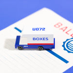 Close up of a Candylab wooden mail van toy on a blue ballot paper