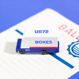 Close up of a Candylab wooden mail van toy on a blue ballot paper