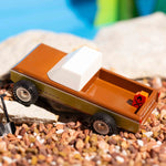 Close up of the Candylab handmade wooden sierra longhorn pickup truck toy on some small brown stones