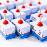 Group of Candylab handmade wooden plumbing truck toys lined up on a white background