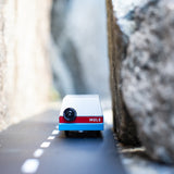 Candylab blue wooden mule car toy driving on a rubber road between two stones