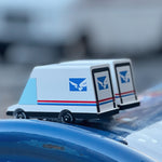 2 Candylab collectable miniature post van toys on a blue postbox