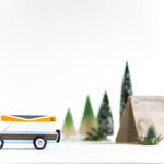 Side of the Candylab childrens blue car toy on a white background in front of some small tree and tent toys