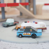 4 Candylab rust patrol toon cars on a play road with a parking garage in the background.