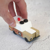 Adult hand pushing the Candylab wooden diecast safari Gira drifter adventure toy truck showing scale