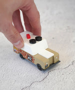 Adult hand pushing the Candylab wooden diecast safari Gira drifter adventure toy truck showing scale