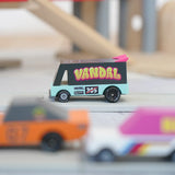 Candylab seafoam vandal van on a playroad with a parking garage in the background.