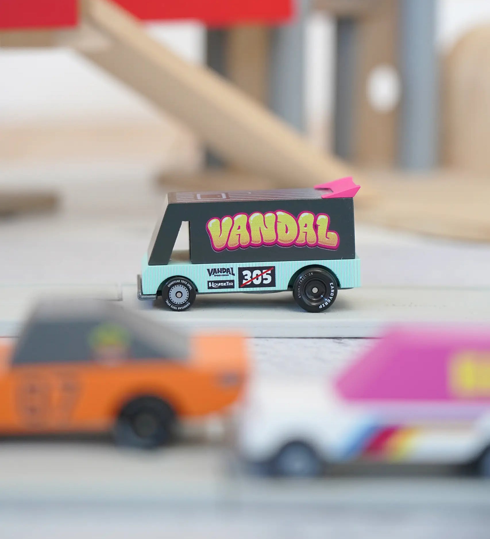Candylab seafoam vandal van on a playroad with a parking garage in the background.