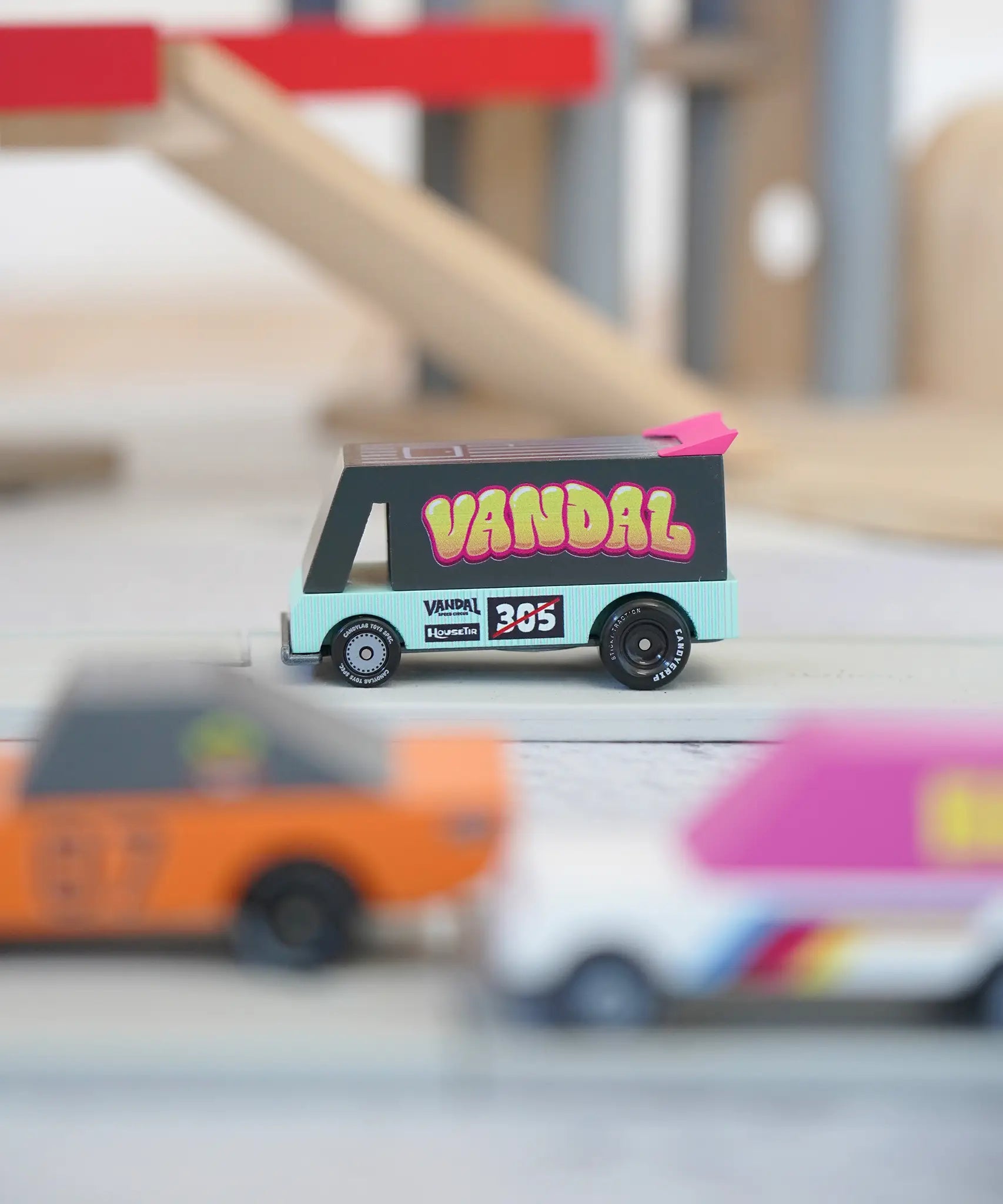 Candylab seafoam vandal van on a playroad with a parking garage in the background.
