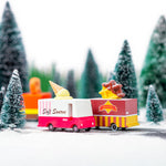 Candylab wooden ice cream and waffle truck toys on a toy road next to some miniature trees and snow