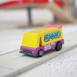 A Candylab wooden diecast yellow speed vandal toy van with a pink spoiler and decals on a playroad
