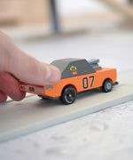 Adult hand pushing the Candylab wooden diecast stormduker orange muscle toy car showing scale