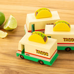 3 Candylab solid wooden taco van toys on a wooden chopping board next to a sliced lime
