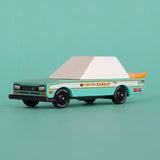 Candylab wooden diecast teal tora racer toy car in front of a light green background.