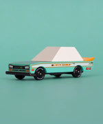 Candylab wooden diecast teal tora racer toy car in front of a light green background.