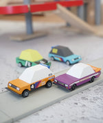 4 Candylab Tokyo heat toon cars on a play road with a parking garage in the background.