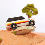 Close up of the Candylab wooden range rover car toy in some sand on a miniature desert scene