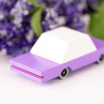 Candylab childrens wooden bberry candycar on a white background next to some purple flowers