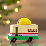 Close up of the Candylab wooden taco van toy truck in front of some Christmas lights