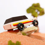 Close up of the Candylab wooden Wanderer SUV car toy on a small rock in some sand