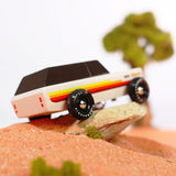 Close up of the Candylab wooden Wanderer SUV car toy on a small rock in some sand