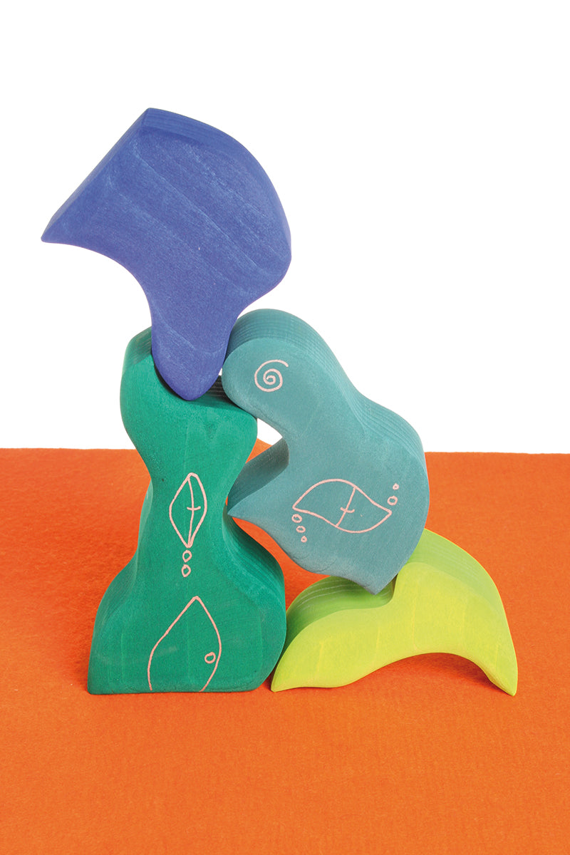Pieces from the Grimm's casa aqua wooden toy stacking puzzle stacked up high. Four piece simple wooden block puzzle toy in a mix of blue and green colours. 
