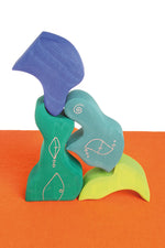 Pieces from the Grimm's casa aqua wooden toy stacking puzzle stacked up high. Four piece simple wooden block puzzle toy in a mix of blue and green colours. 