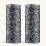 A pair of charcoal floss refills on a cream background
