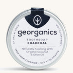 A tin of the Georganics charcoal toothsoap on a cream background