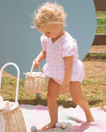 Two children holding the Olli Ella Rattan Berry Basket with Lining – Pansy Floral and Gumdrop in their hands. Inside each basket are colourful pink