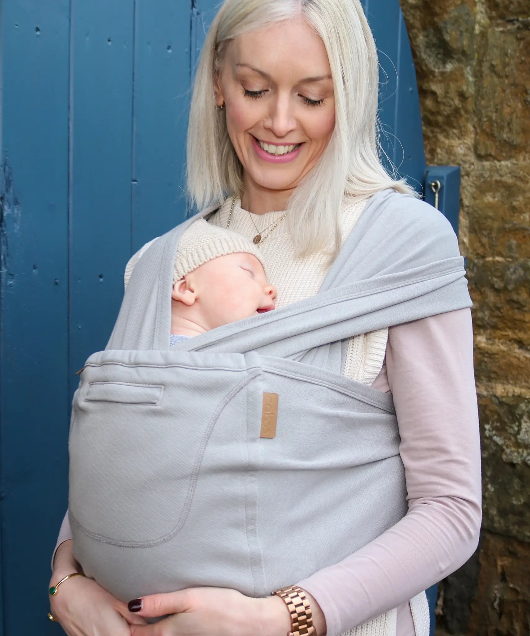 Front of mother carrier a baby in a Close Caboo Organic Baby soft structure cotton Carrier in porpoise showing wide shoulder straps 